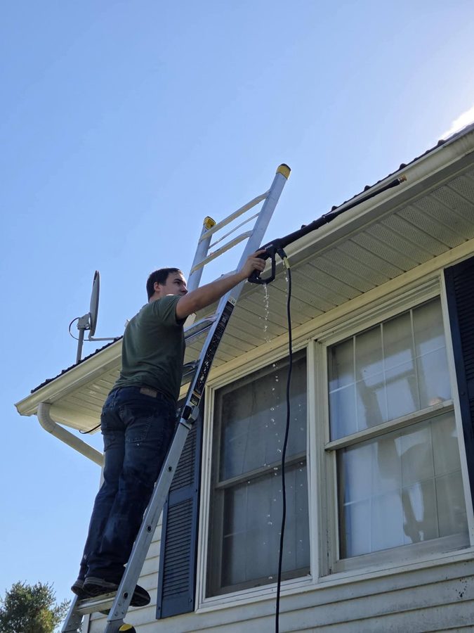 Bryce cleaning gutters — Brutus's Handyman Services